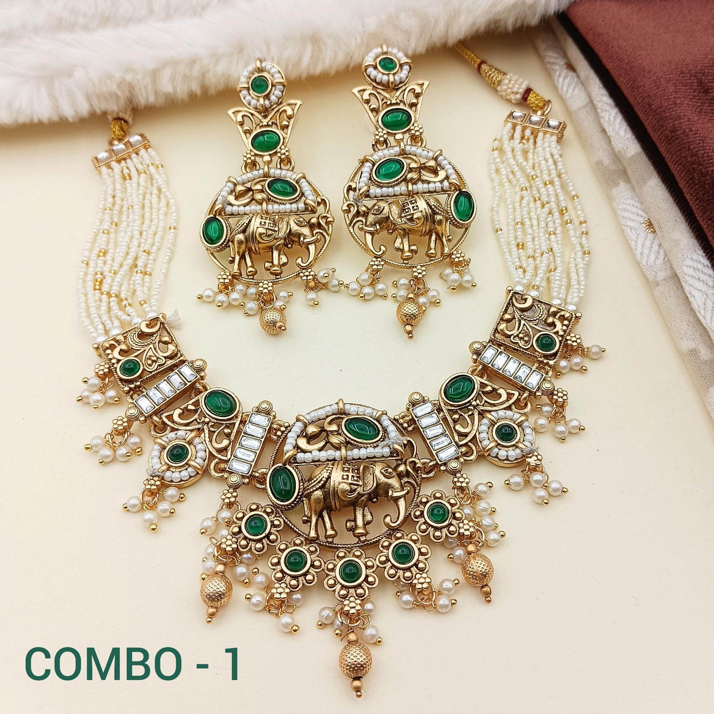 Rajputi elephant design necklace set with green stones and pearl details in gold finish