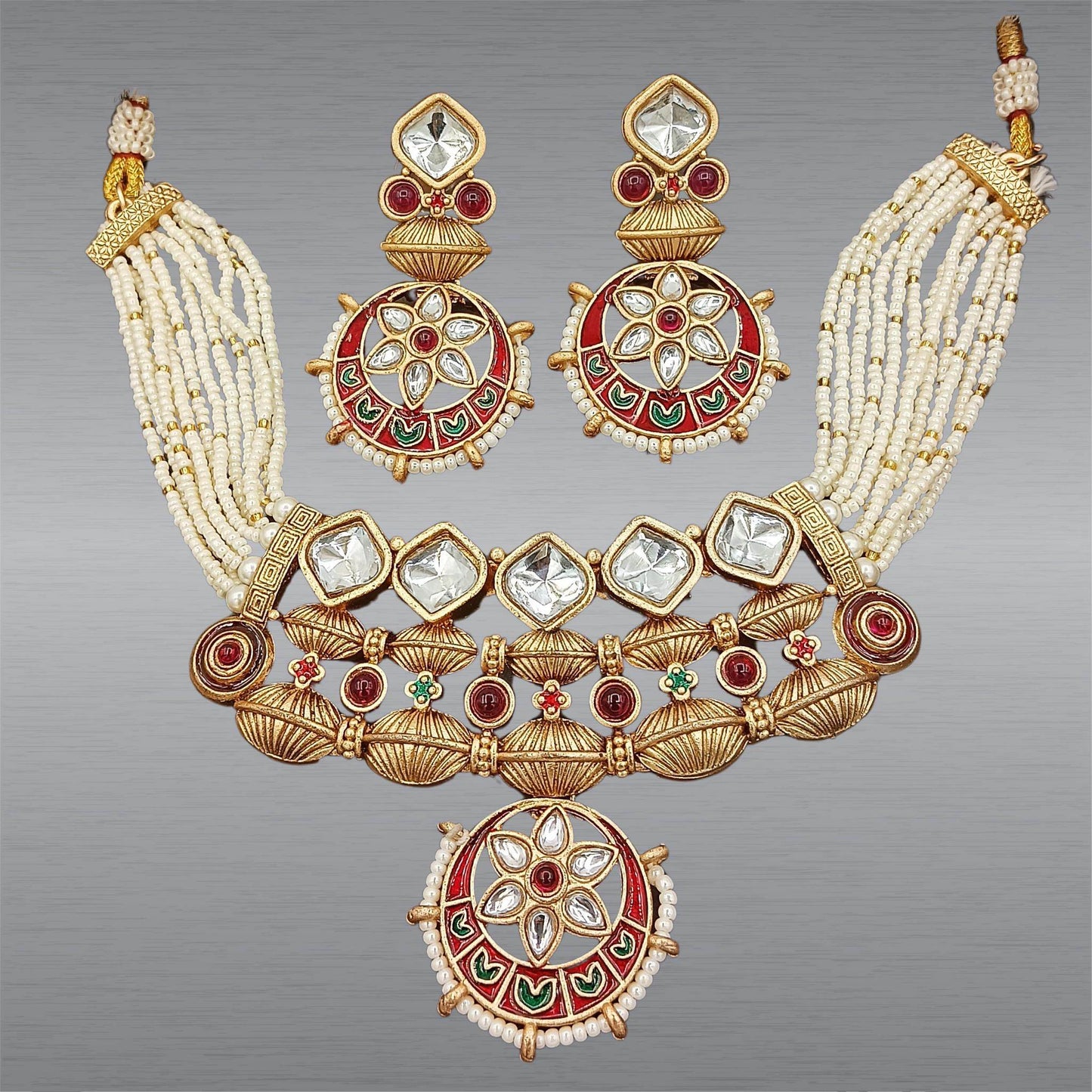 Rajwadi jewelry set for women with traditional gold tone, red and green enamel work, and pearl bead strands