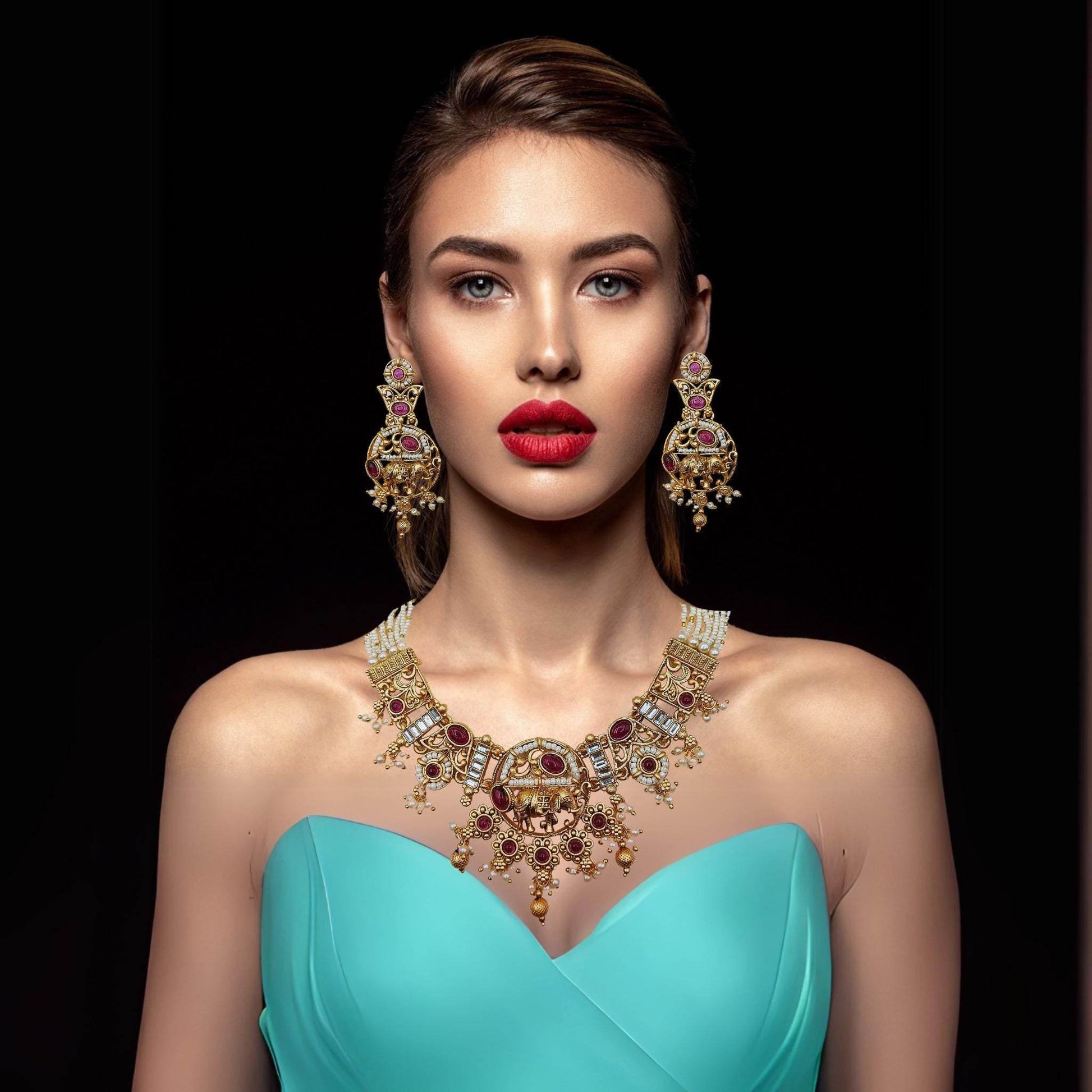 Elegant Rajputi elephant design necklace set with matching earrings worn by a woman in a turquoise dress